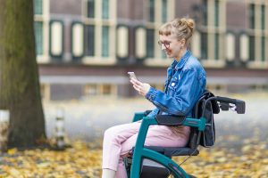 a woman sitting in a chair using a cell phone